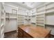 Large walk-in closet with custom shelving, a wooden island, and plenty of storage space at 15427 E Firerock Country Club Dr, Fountain Hills, AZ 85268