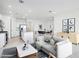 Spacious open-concept living room with modern furnishings, leading to a dining area and stylish kitchen at 15627 W Hackamore Dr, Surprise, AZ 85387