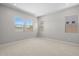 An empty, bright bedroom with three windows and neutral carpet, ready for personalization and comfortable living at 15642 W Georgia Dr, Surprise, AZ 85379