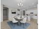 Bright dining area with a modern chandelier, a marble table with six chairs, and an adjacent island kitchen area at 15642 W Georgia Dr, Surprise, AZ 85379