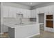 Modern kitchen with white cabinets, a center island, and neutral backsplash at 15642 W Georgia Dr, Surprise, AZ 85379