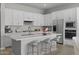 Well-equipped kitchen with white cabinets, stainless steel appliances, and a large island with seating at 15642 W Georgia Dr, Surprise, AZ 85379