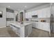 Bright kitchen with white cabinets, quartz countertops, large island, and stainless steel appliances at 15642 W Georgia Dr, Surprise, AZ 85379
