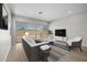 Bright living room featuring neutral tones, modern furnishings, and sliding glass doors to the backyard at 15642 W Georgia Dr, Surprise, AZ 85379