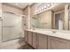Bathroom featuring a dual sink vanity, large mirror, and glass door shower at 16240 W Talara Way, Surprise, AZ 85374