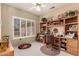 Cozy bedroom/office with built-in bookshelves, natural light from the window, and a ceiling fan at 16240 W Talara Way, Surprise, AZ 85374