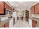 Inviting kitchen featuring wood cabinets, granite countertops, white appliances, and an adjacent dining area at 16240 W Talara Way, Surprise, AZ 85374