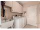 Practical laundry room with washer, dryer, sink, and storage cabinets at 16240 W Talara Way, Surprise, AZ 85374