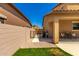 View of a low maintenance backyard featuring gravel, green grass, iron gate, and covered patio with outdoor dining set at 16245 W Papago St, Goodyear, AZ 85338