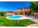 This backyard features a pool surrounded by lush green grass and a covered patio, perfect for outdoor entertaining at 16245 W Papago St, Goodyear, AZ 85338