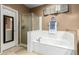 Modern bathroom features a soaking tub, glass-enclosed shower, and neutral tile flooring at 16245 W Papago St, Goodyear, AZ 85338