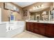 Bathroom featuring a bathtub, wood cabinets, and a large vanity with a mirror at 16245 W Papago St, Goodyear, AZ 85338