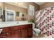 Bathroom featuring a vanity with wood cabinets, a large mirror, and a shower with a patterned curtain at 16245 W Papago St, Goodyear, AZ 85338