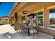 Backyard features a covered patio with outdoor dining, ceiling fan, and mounted TV, ideal for outdoor relaxation at 16245 W Papago St, Goodyear, AZ 85338