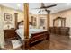 Bedroom showcasing a four-poster bed, wood floors, and an ensuite bathroom at 16245 W Papago St, Goodyear, AZ 85338