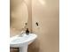 Close-up of a powder room with a pedestal sink and a round mirror at 16245 W Papago St, Goodyear, AZ 85338