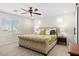 Comfortable bedroom with a large window, plush bedding, and ceiling fan for a relaxing atmosphere at 18381 W La Senda Dr, Surprise, AZ 85387