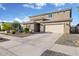 Two story home featuring a large driveway, desert landscaping, and a two car garage at 18381 W La Senda Dr, Surprise, AZ 85387