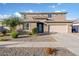 Exterior of a two-story home with a two-car garage, desert landscaping including flowering bushes, a sidewalk and driveway at 18381 W La Senda Dr, Surprise, AZ 85387