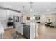 Open-concept kitchen with stainless steel appliances and a center island that flows into the spacious living area at 18381 W La Senda Dr, Surprise, AZ 85387