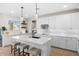 Bright kitchen featuring a large island, white cabinets, and stainless steel appliances at 18381 W La Senda Dr, Surprise, AZ 85387