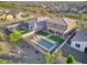 A bird's eye view of a property's backyard including a pool with lounge chairs, a barbeque, and a grassy area at 18381 W La Senda Dr, Surprise, AZ 85387