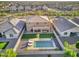 An aerial view shows a home's backyard including a pool with lounge chairs, a barbeque, and a grassy area at 18381 W La Senda Dr, Surprise, AZ 85387