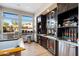 Bar area with dark cabinetry, a window view, and countertop drink dispenser at 19777 N 76Th St # 1106, Scottsdale, AZ 85255