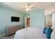 Light-filled bedroom featuring a ceiling fan, TV, and light-colored dresser at 19777 N 76Th St # 1106, Scottsdale, AZ 85255