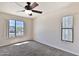 Carpeted bedroom with a ceiling fan, large window, and smaller window at 2025 E Campbell Ave # 248, Phoenix, AZ 85016