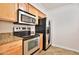 Modern kitchen with stainless steel appliances and ample storage in wood cabinets at 2025 E Campbell Ave # 248, Phoenix, AZ 85016