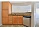 Galley kitchen features stone countertops, wood cabinetry, and stainless steel dishwasher at 2025 E Campbell Ave # 248, Phoenix, AZ 85016