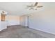 Cozy living room featuring neutral carpet, a ceiling fan, and a view into the adjacent kitchen at 2025 E Campbell Ave # 248, Phoenix, AZ 85016