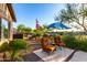 Backyard lounge area with desert landscaping, seating, and an umbrella to keep you cool at 20558 N 263Rd Dr, Buckeye, AZ 85396