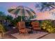 Relaxing outdoor seating area with an umbrella, ideal for enjoying the peaceful surroundings and sunset views at 20558 N 263Rd Dr, Buckeye, AZ 85396