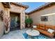 Inviting courtyard with an outdoor couch, decorated tile table, and potted plants near the entrance at 20558 N 263Rd Dr, Buckeye, AZ 85396