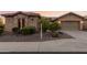 Charming home exterior with stone accents, desert landscaping and a lush, green lawn at 20558 N 263Rd Dr, Buckeye, AZ 85396