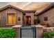 Charming front entrance with stone accents, gated courtyard, and desert landscaping at 20558 N 263Rd Dr, Buckeye, AZ 85396