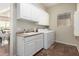 Functional laundry room with white cabinetry, sink, and modern washer and dryer set at 20558 N 263Rd Dr, Buckeye, AZ 85396