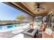 Relaxing covered patio with a ceiling fan, views of the pool, and comfortable seating at 20558 N 263Rd Dr, Buckeye, AZ 85396