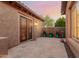 Private patio with beautiful landscaping, travertine pavers, and custom shade that offers an inviting outdoor retreat at 20558 N 263Rd Dr, Buckeye, AZ 85396