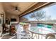 Covered patio area featuring outdoor dining and a view of the pool and manicured backyard at 20558 N 263Rd Dr, Buckeye, AZ 85396