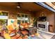 Cozy covered patio with a fireplace, comfortable seating, and a ceiling fan for relaxing outdoors at 20558 N 263Rd Dr, Buckeye, AZ 85396