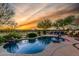 Backyard pool with mature trees, relaxing lounge chairs and desert sunset at 20558 N 263Rd Dr, Buckeye, AZ 85396