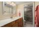 Bathroom featuring vanity with new faucet and stone tiled shower with glass door at 2407 W Rue De Lamour Ave, Phoenix, AZ 85029