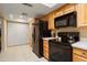 Well-lit kitchen with wooden cabinets, black appliances, spacious countertops, and tile flooring at 2407 W Rue De Lamour Ave, Phoenix, AZ 85029