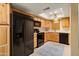 Updated kitchen with wood cabinetry, black appliances, skylight, and tile flooring at 2407 W Rue De Lamour Ave, Phoenix, AZ 85029