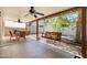 This covered patio features two ceiling fans, a dining table and a charming swing for relaxing outdoors at 2407 W Rue De Lamour Ave, Phoenix, AZ 85029