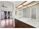 Bathroom vanity with dual sinks, dark wood cabinets, quartz countertop, large mirrors and hardwood floors at 250 W Juniper Ave # 22, Gilbert, AZ 85233
