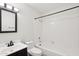 Bathroom with shower/tub combo, dark vanity, and a white sink at 250 W Juniper Ave # 22, Gilbert, AZ 85233